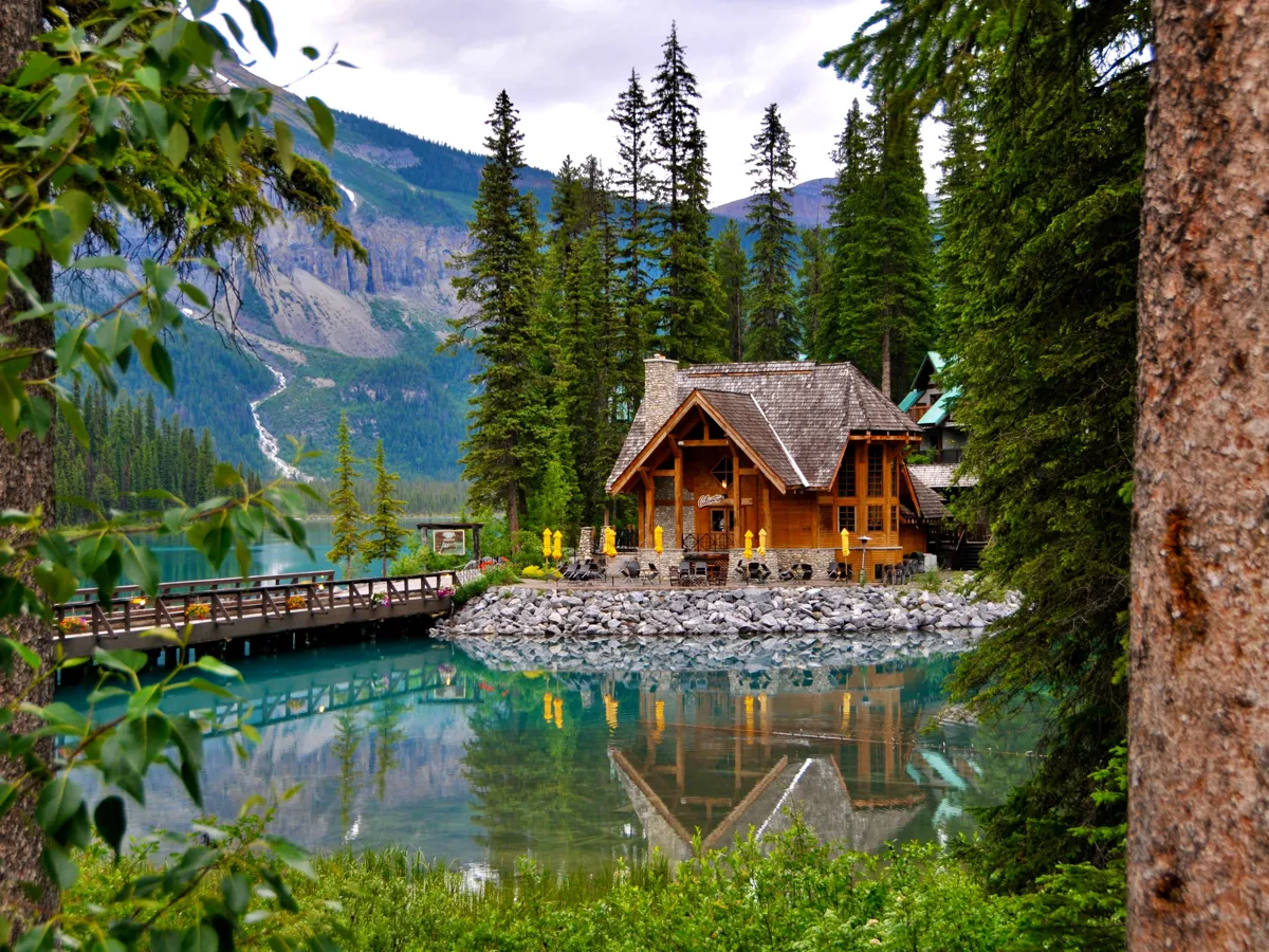 Clear mountain lake at golden hour with a small wooden dock leading to the shoreline